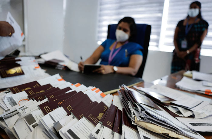 Officials prepare the passports of the applicants at the Sri Lanka&apos;s Immigration and Emigration Department